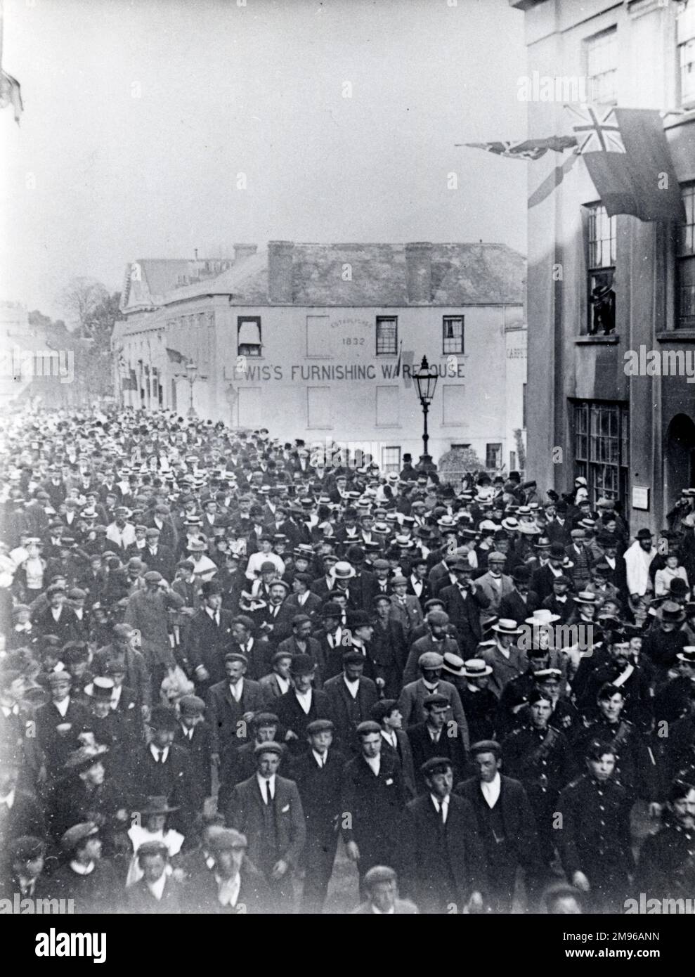 Crowds of people in the roadway at Victoria Place, Haverfordwest, Pembrokeshire, Dyfed, South Wales, probably during a circus procession.  Lewis's Furnishing Warehouse can be seen in the background. Stock Photo