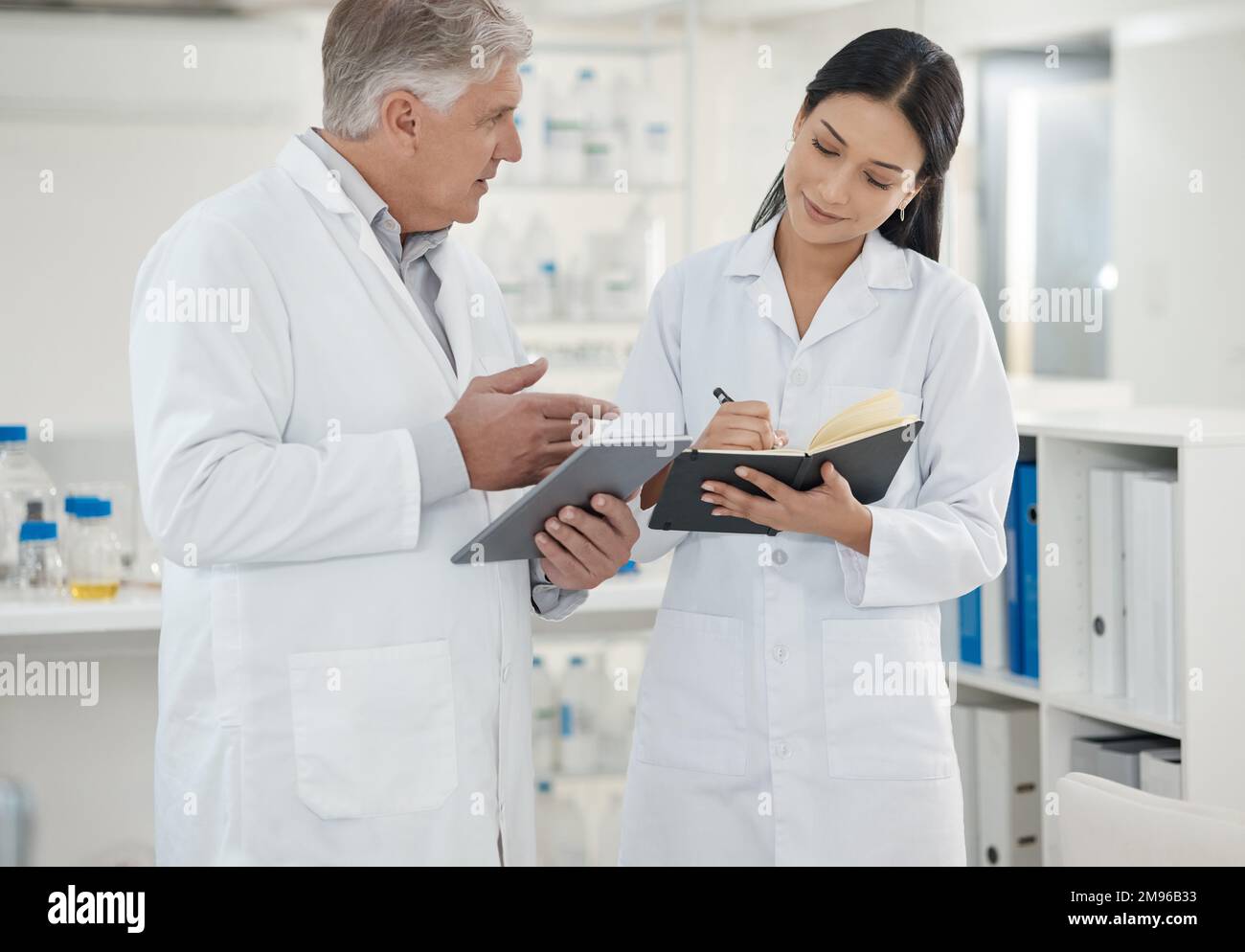 Reporting on the latest case to the lab manager. two scientists using a digital tablet together in a lab. Stock Photo