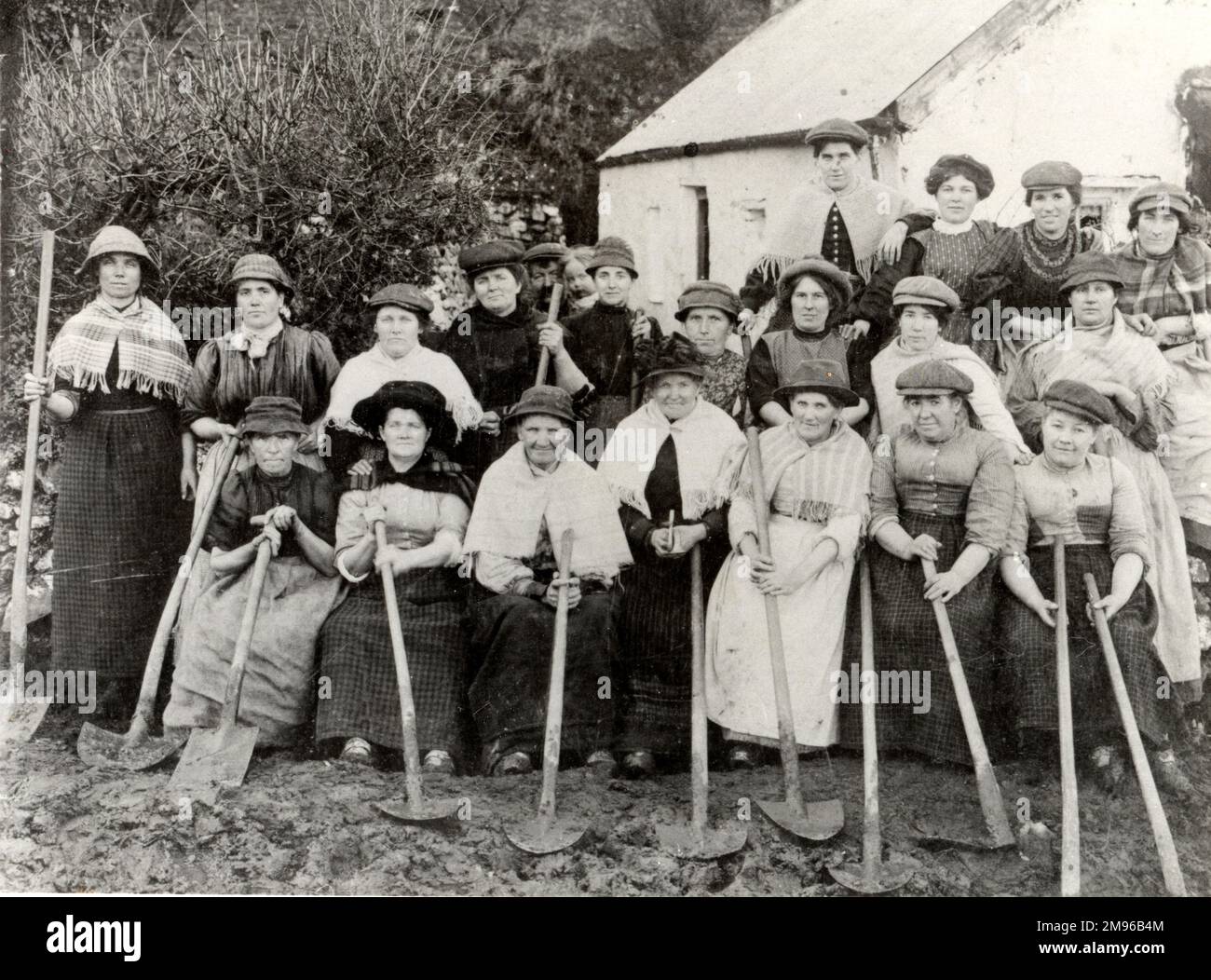 A group of twenty Welsh women road builders in Pembrokeshire, Dyfed, South Wales, holding their spades.  They built the road to Hook in 1903-4 to facilitate transport to the colliery.  They also worked at the colliery itself and gathered ‘boughs’ which were used as pit props, for which they were paid ninepence per hundredweight. Stock Photo