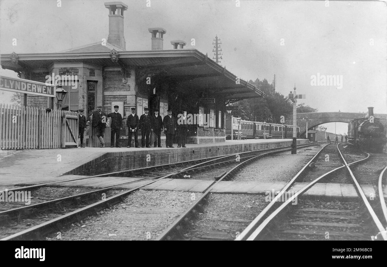 View of Clynderwen (or Clunderwen) Railway Station in Pembrokeshire, South Wales, on the Great Western Railway.  Seven men and a boy stand in a line on the platform, probably including the station master, ticket collector and porters.  Four men on the line in the distance near the bridge are testing the track. Stock Photo