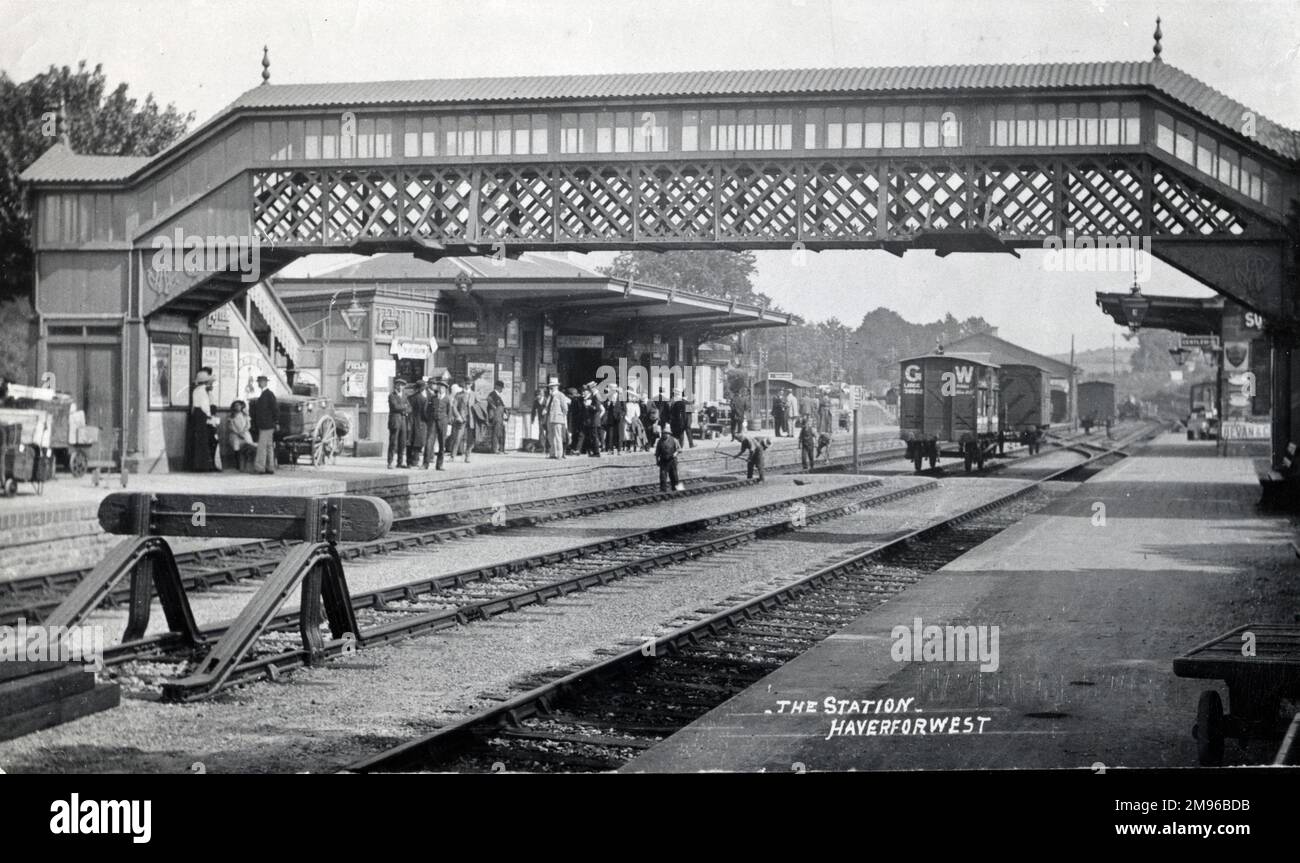 Passengers waiting for the 1040 to Paddington, on the up platform of Haverfordwest Railway Station in Pembrokeshire, South Wales.  At the time a return ticket would have set them back £3 12s 6d (three pounds, twelve shillings and sixpence). Stock Photo