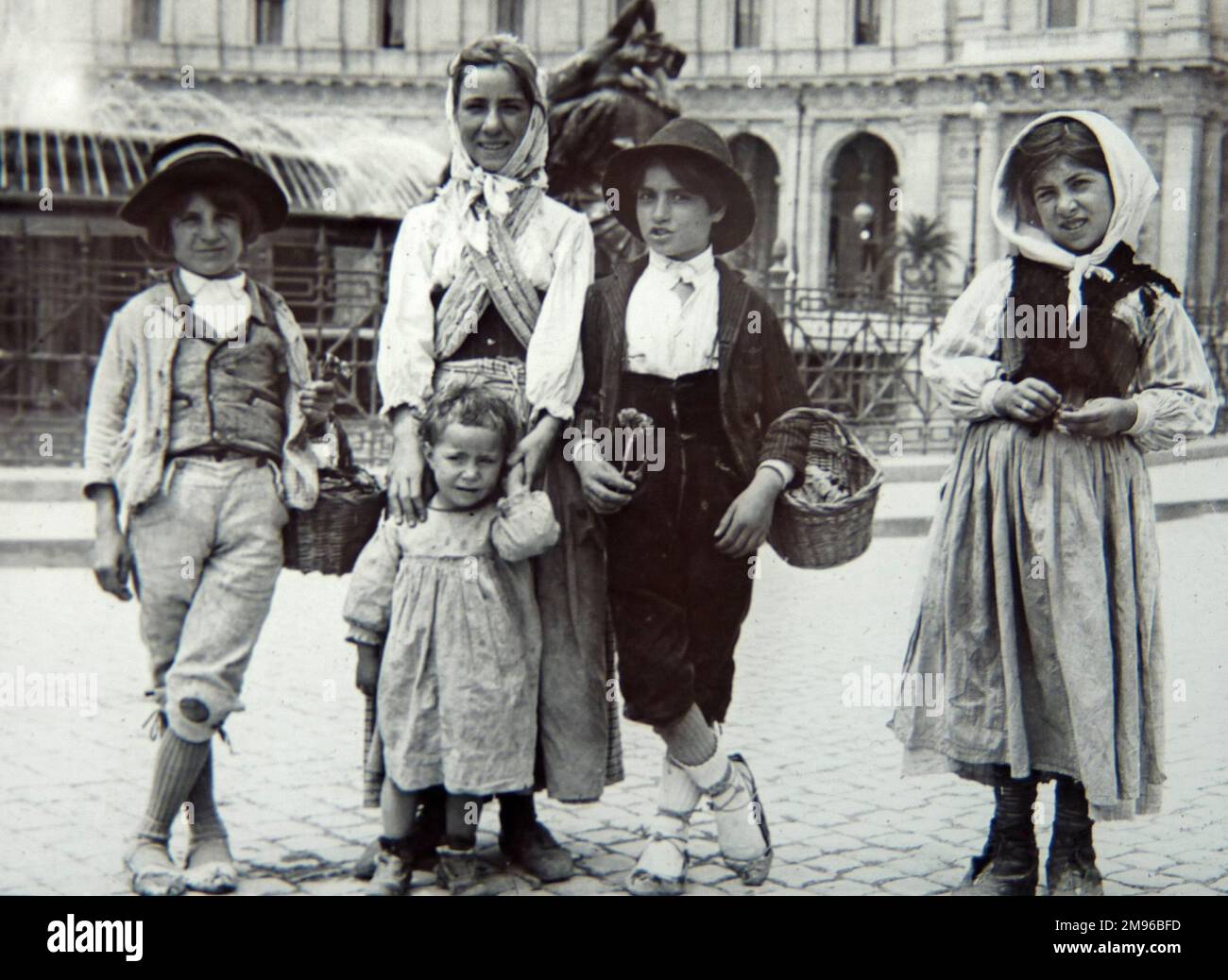 Five Romany children in traditional dress, selling flowers on the streets of Dublin, Ireland. Stock Photo