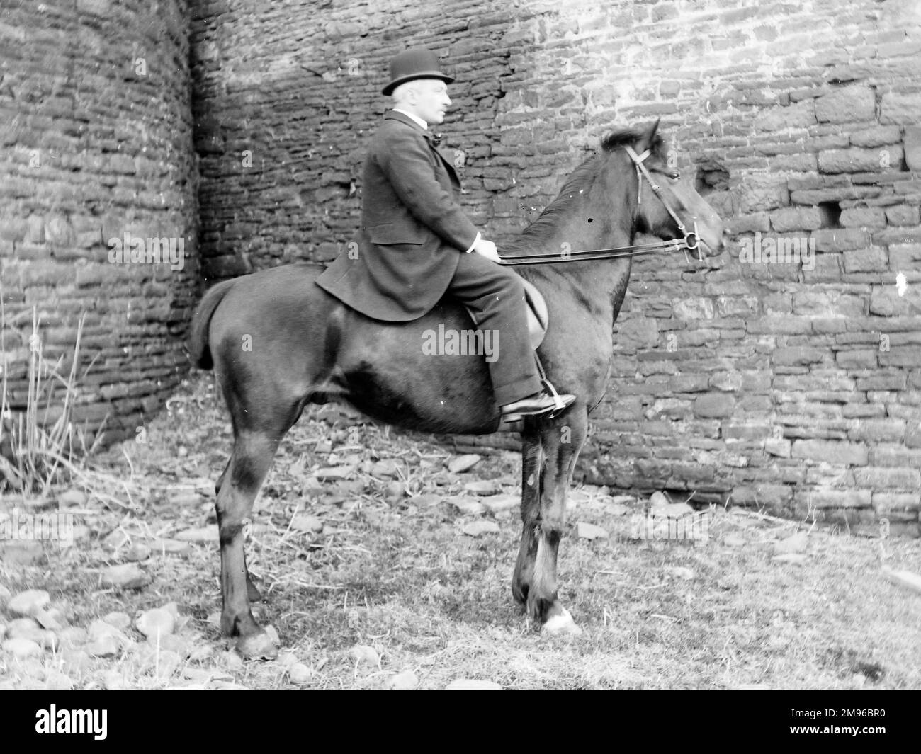 A gentleman on horseback in front of a stone wall, probably somewhere in Mid Wales. Stock Photo