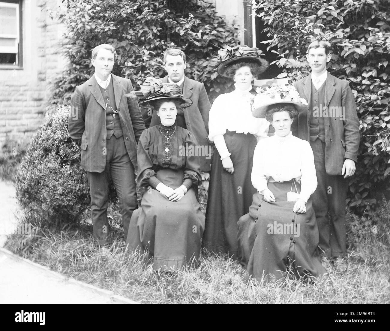 A family group of six -- three men and three women -- in a garden in