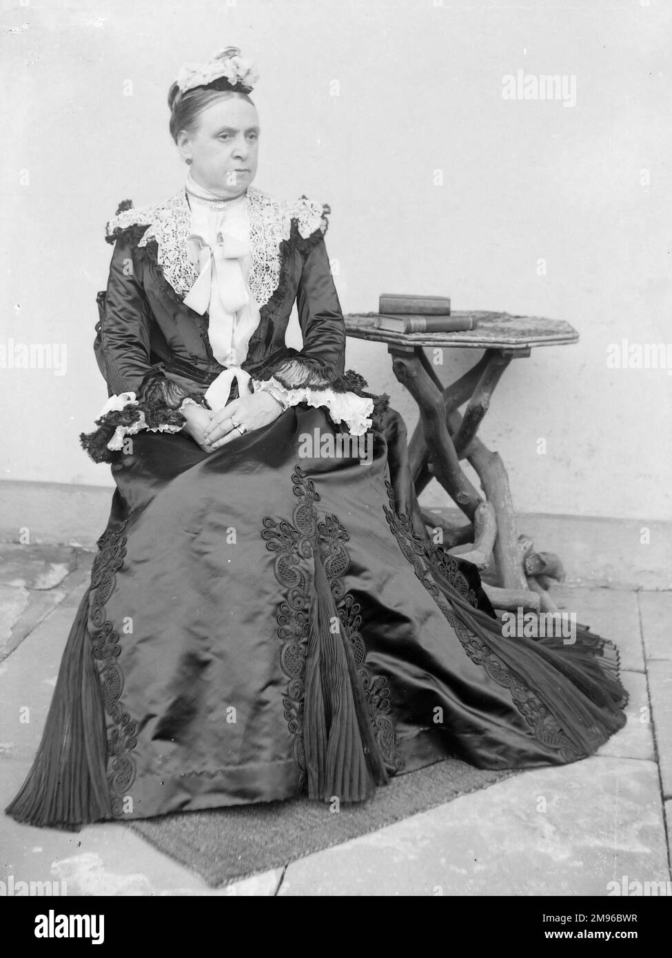 Sitting Women's Wear Dresses A Middle Aged Woman In A Victorian Style Satin Dress Sitting Next Sitting Women's Wear Dresses A Middle Aged Woman In A Victorian Style Satin Dress Sitting Next