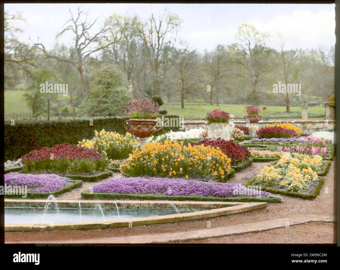 View of the formal garden in the spring, at Abbotswood, Stow on the Wold, Gloucestershire, with grass and trees in the background.  The gardens were created by Sir Edwin Lutyens. Stock Photo