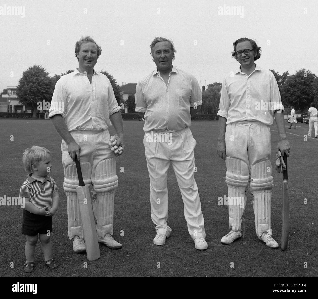 Three cricketers, two of them batsmen, pose for their photograph on a