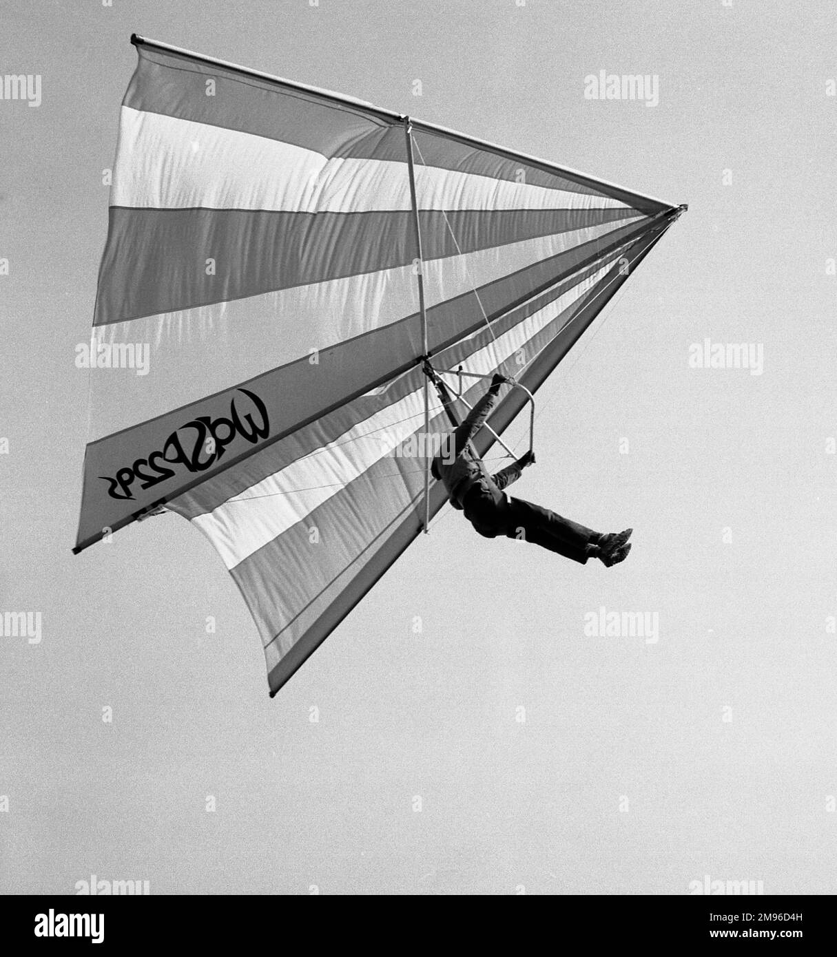 A man flies through the air on a hang glider. Stock Photo