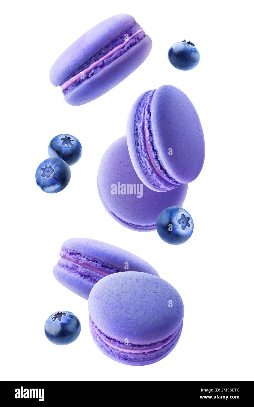 Blue macarons and blueberries falling, vertical isolated on white background Stock Photo