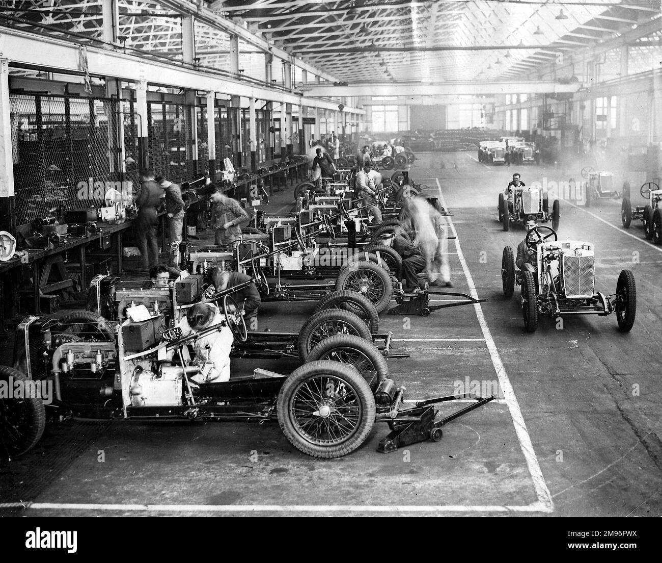 MG Midget chassis assembly and being driven, 1932 Stock Photo Alamy