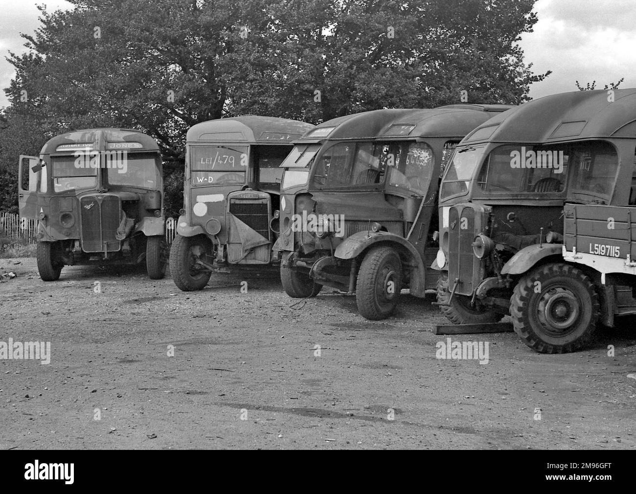 Vehicles in a yard, waiting to be repaired, or perhaps they are beyond repair and are being held for spare parts. Stock Photo
