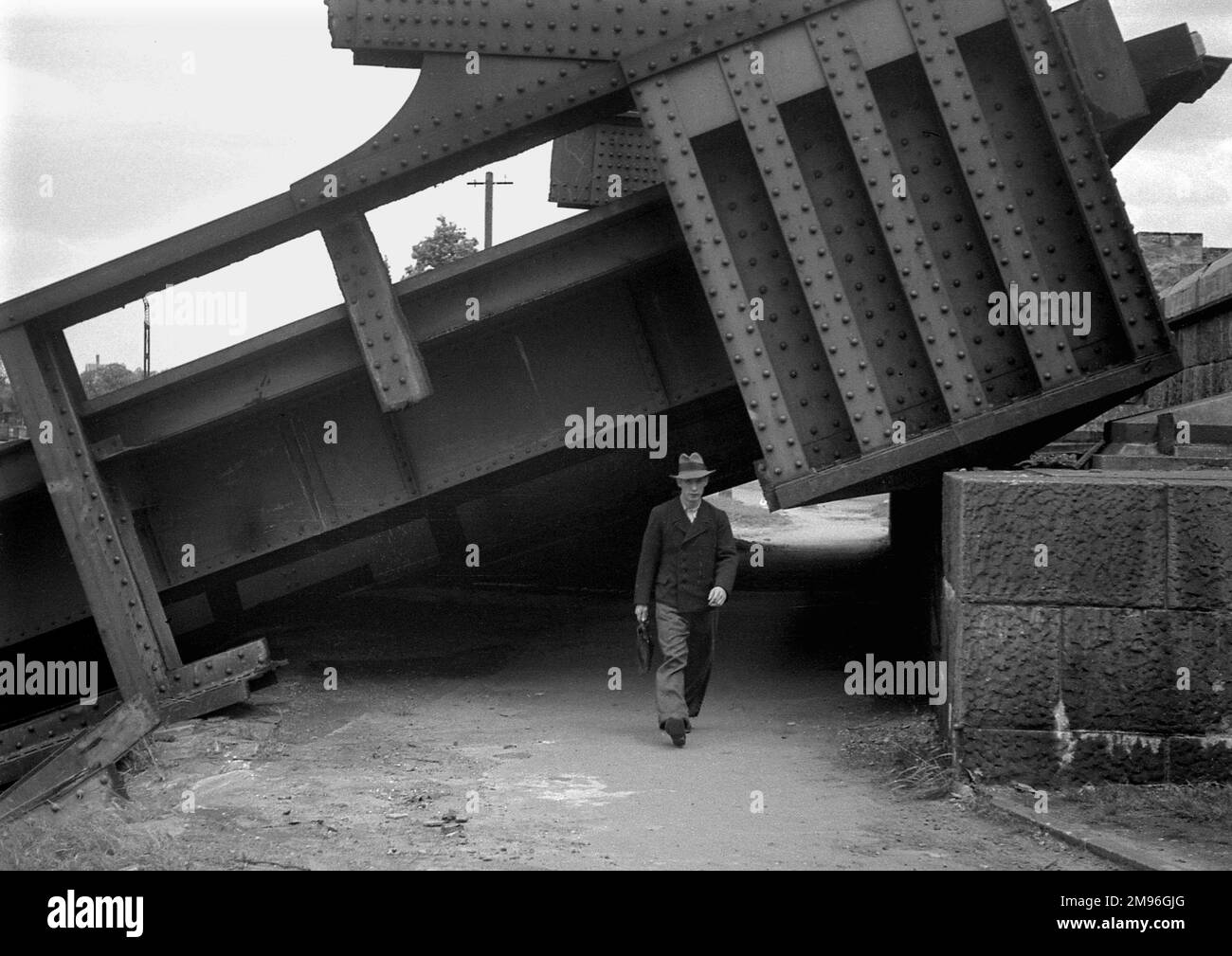A man walking out from under a collapsed metal structure during the Second World War. Stock Photo