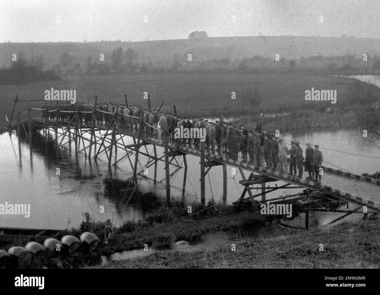 A large number of soldiers standing on a bridge across the river at