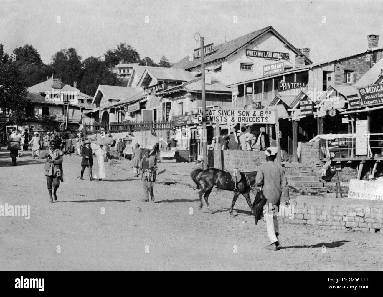 Street scene in Murree, India (now part of Pakistan), with a restaurant, shops and pedestrians. Stock Photo