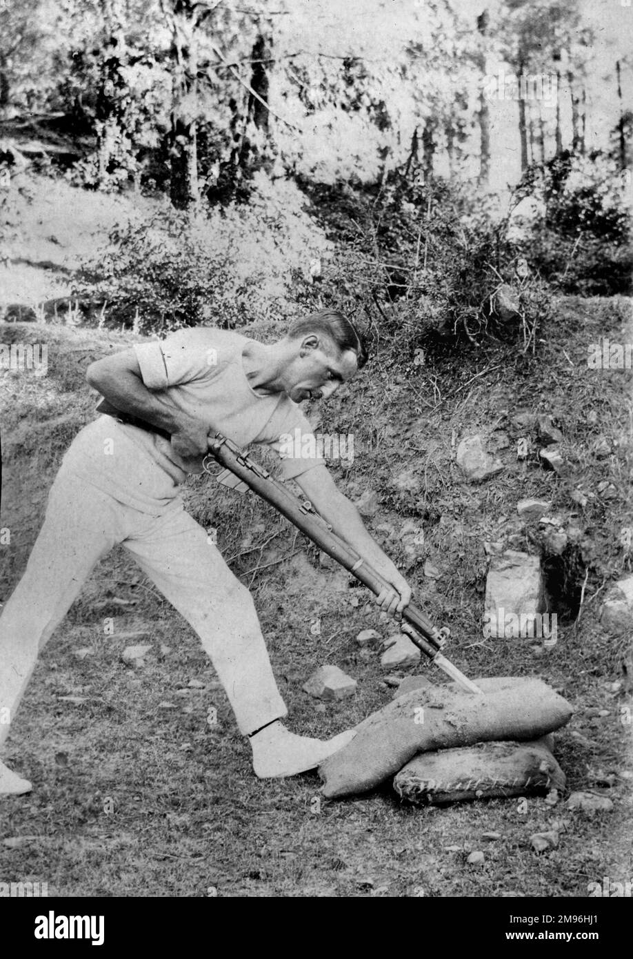 Soldier in side view, stabbing a stuffed sack with a bayoneted rifle, India. Stock Photo