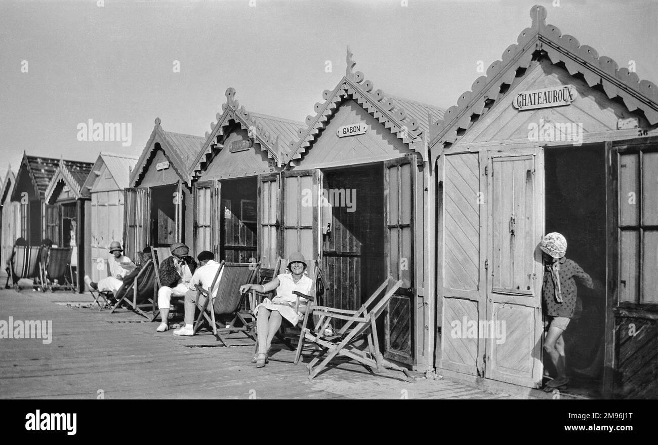 People outside their beach huts at Cayeux-sur-Mer, northern France, on a sunny day. Stock Photo