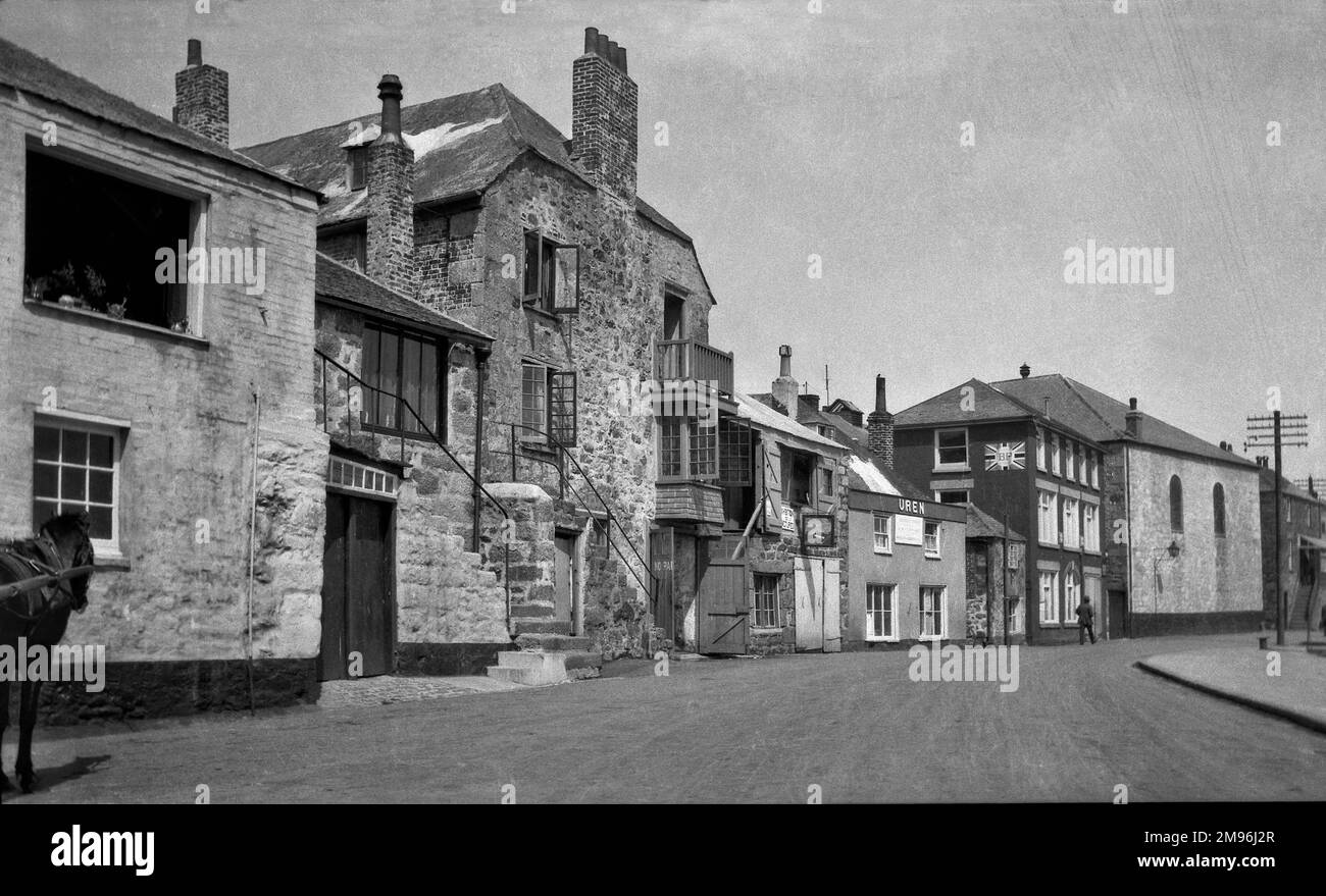 A street scene in St Ives, Cornwall, with houses and shops, and a sign advertising BP. Stock Photo