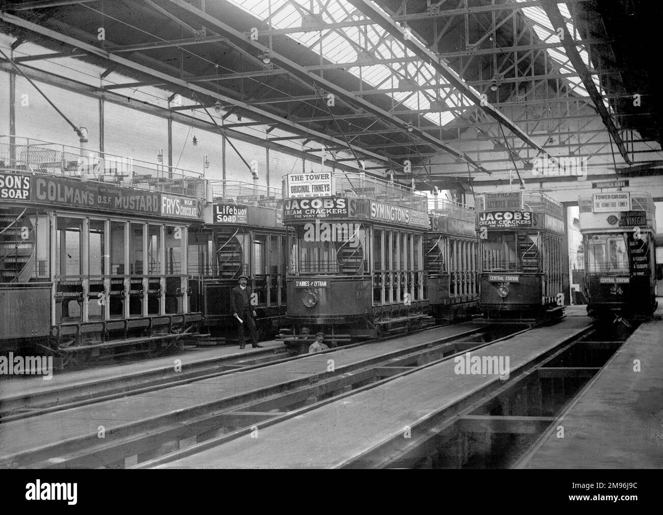 Interior view of a tramshed at Lytham St Annes, Lancashire, showing various trams with advertising material: Jacob's Cream Crackers, Colman's Mustard, Lifebuoy Soap, Fry's Milk Chocolate and Symington's Coffee Essence.  Seymour Hicks is appearing at the Palace, the Hanneford Family at the Tower Circus, and the Original Finneys at the Tower (Blackpool). Stock Photo