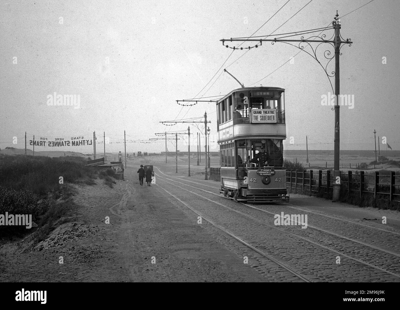 An electric tram on the road at Lytham St Annes, Lancashire, with the driver standing at the front in uniform. Stock Photo