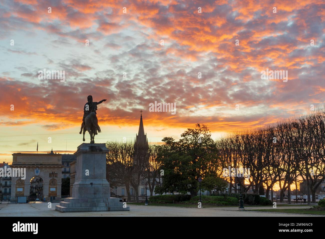 Colorful winter sunrise landscape with Louis XIV equestrian statue and arch of triumph at Promenade du Peyrou public park, Montpellier, France Stock Photo