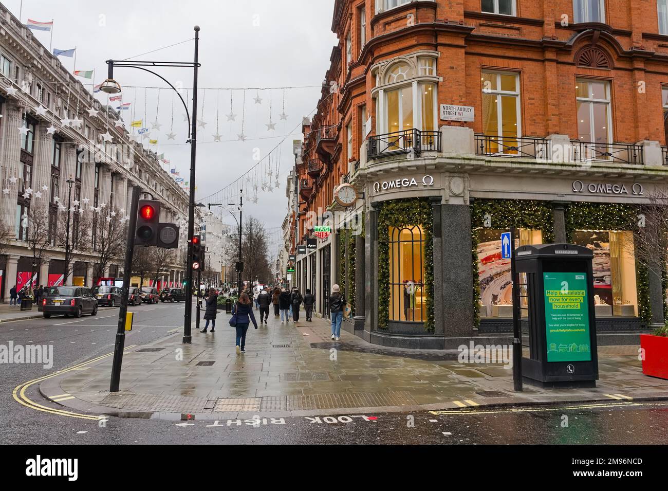 view of Oxford street in the rain with a main OMEGA shop on the corner Stock Photo