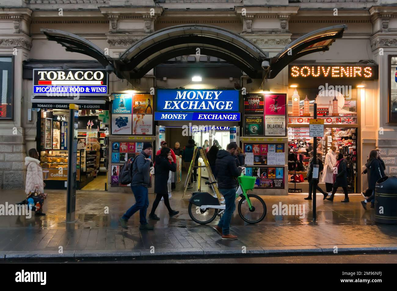 pedestrians walking by brightly lit shops in Piccadilly, Stock Photo