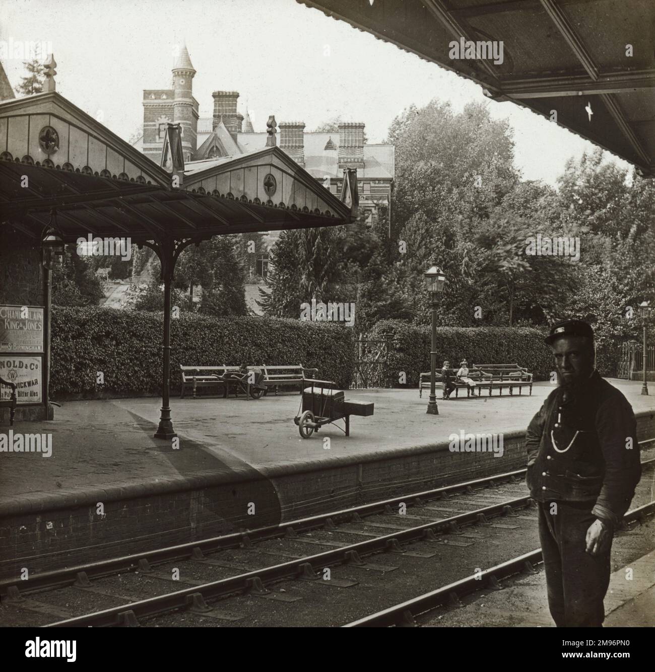 Late Victorian English Railway Station scene with slightly grumpy Station Master awaiting the next arrival. Stock Photo