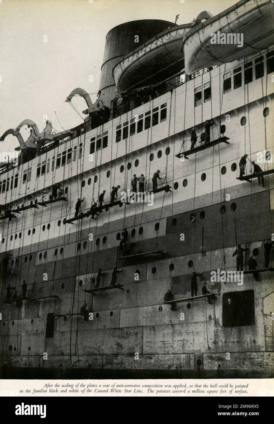 After the scaling of the plates a coat of the anti-corrosive composition was applied, so that the hull could be painted in the black and white of the Cunard White Star Line.  The painters covered a million square feet of surface Stock Photo