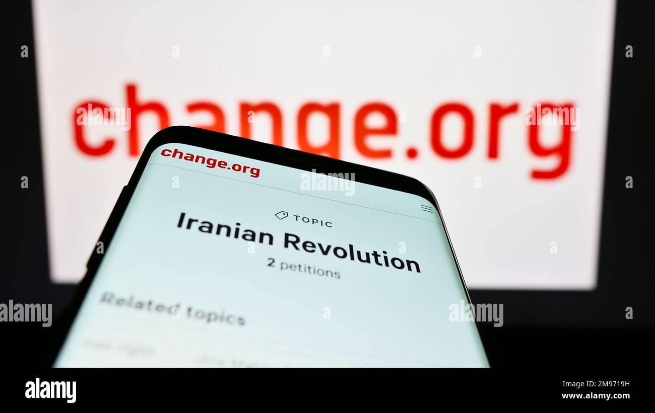 Smartphone with website of American petition platform Change.org PBC on screen in front of logo. Focus on top-left of phone display. Stock Photo