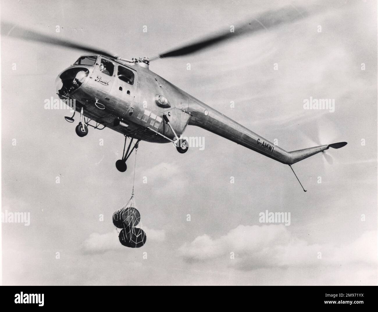 Bristol Sycamore Mk4, G-AMWI, carrying a suspended load of two oil drums. Stock Photo