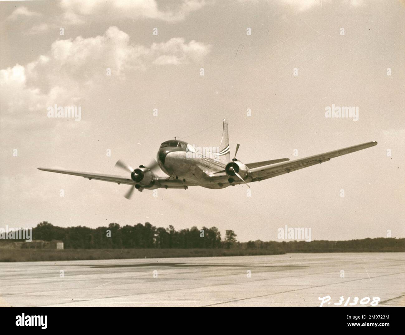 Pat Tibbs demonstrates the Martin 2-0-2 with its port propeller feathered on take-off at maximum gross weight. October 1947. Stock Photo