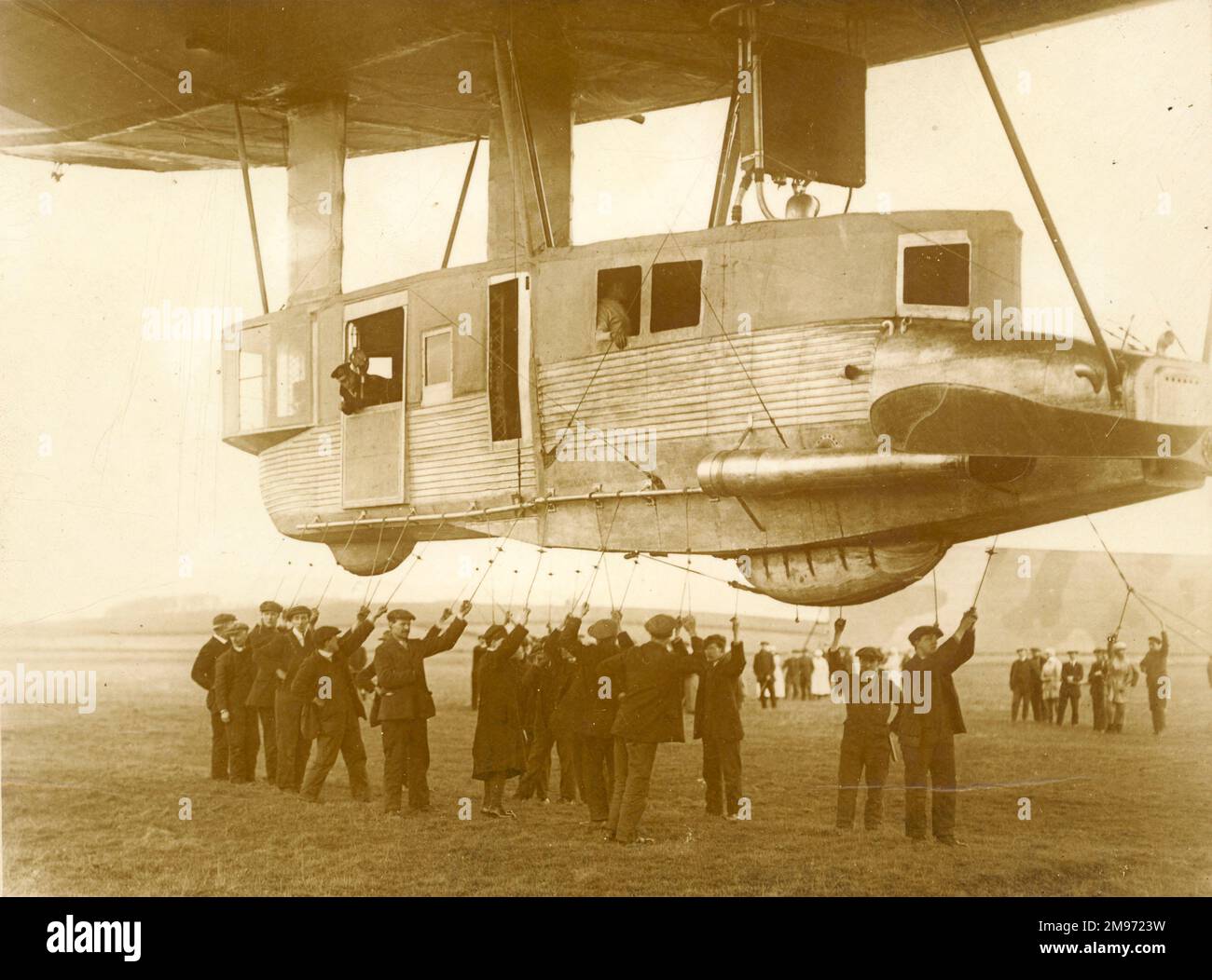 The forward gondola of the R34. The airship is being eased up, preparatory to flight, when the lines held by the groundcrew will be released from the handling rail. 14 March 1919 (the first flight). Stock Photo