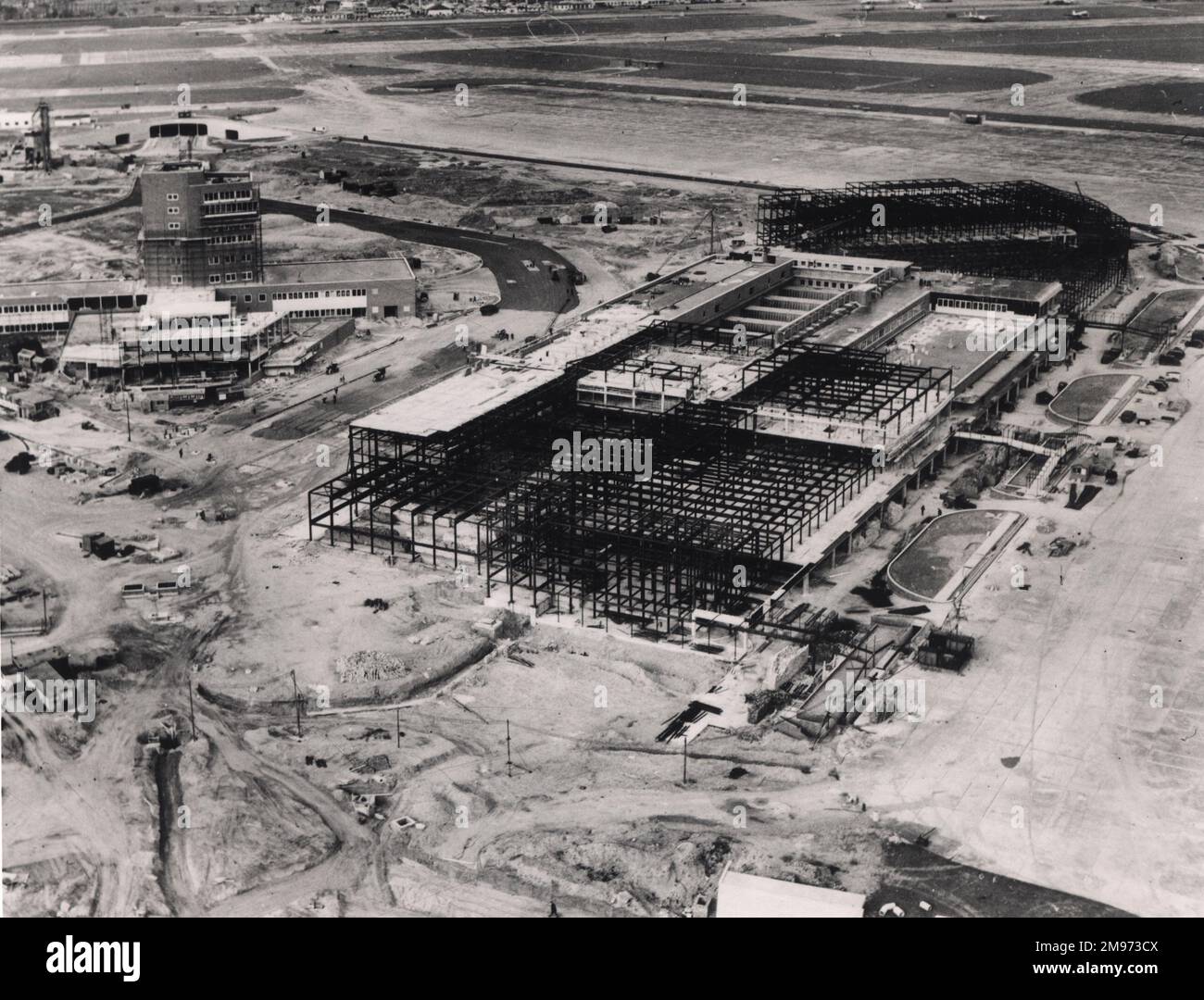 Queens Building, the Europa Terminal and central control tower rise up out of a sea of gravel at Heathrow Airport in the early 1950s. Just above the control tower can be seen the road tunnel. Stock Photo