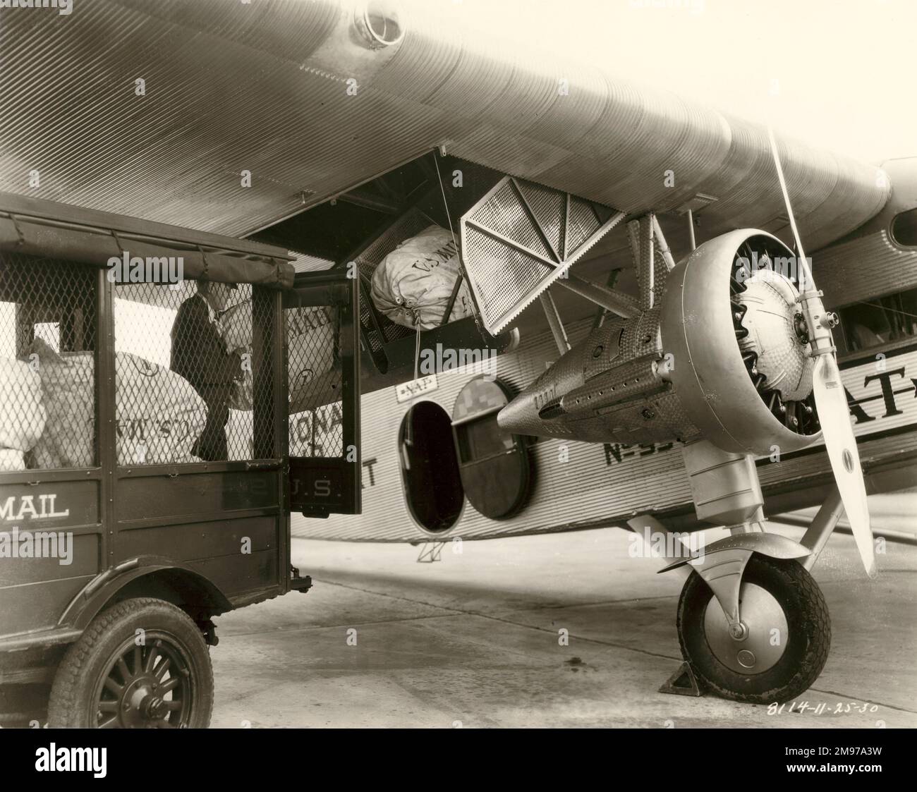 Mail being loaded into a Ford Tri-Motor. circa 1930. Stock Photo