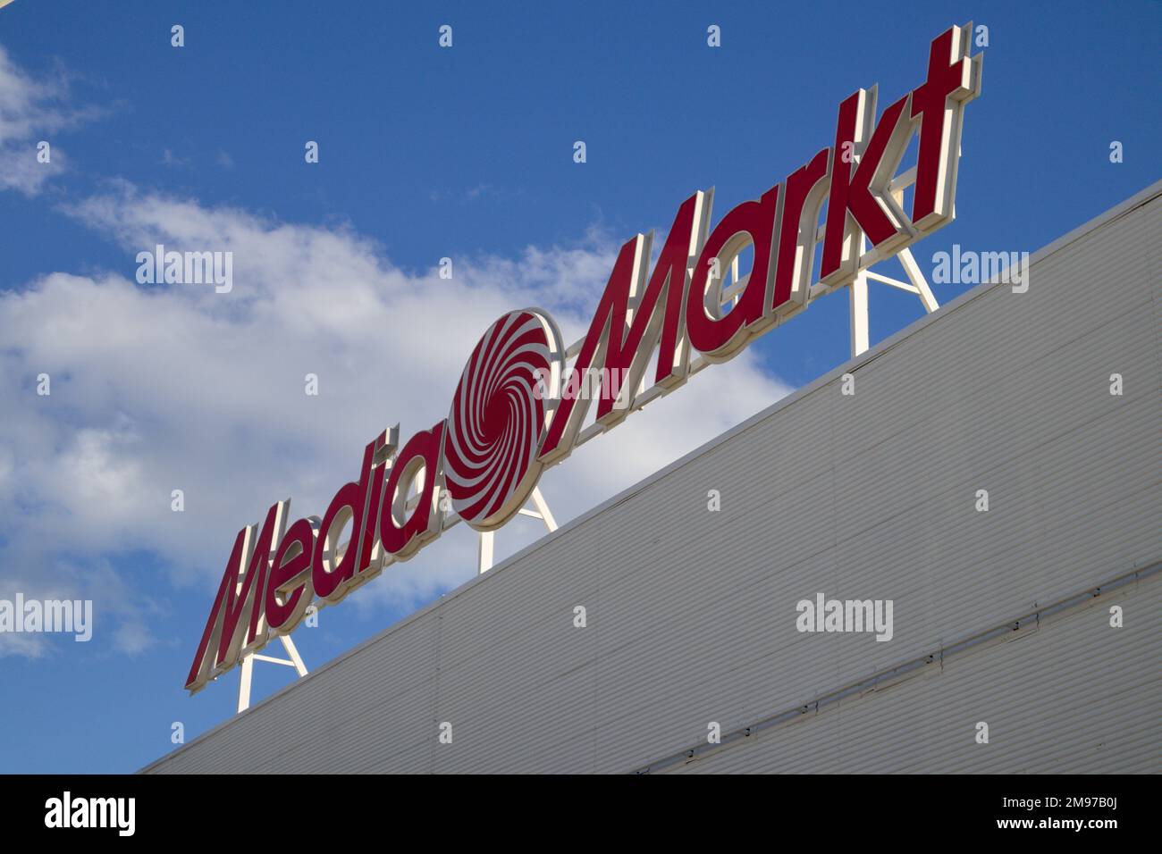 2022. Valencia, Spain. Logo with red letters of the Media Markt brand on one of its stores in Valencia (Spain) with blue sky and clouds behind Stock Photo