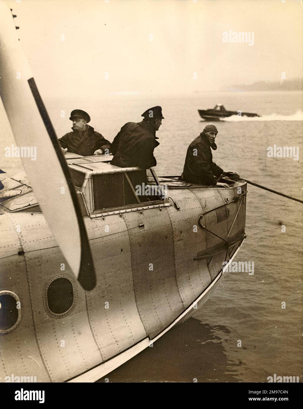 Receiving instructions on flying boats in a Short S8/8 Rangoon flying boat at The Air University, Hamble, Hants. Seaplane Instructor Flt Lt Pascoe (centre) gives instruction on mooring to First Officer F.D. Smith (left) and First Officer J.F. Nicholas, two Imperial Airways pilots. [see also 56006142] Stock Photo