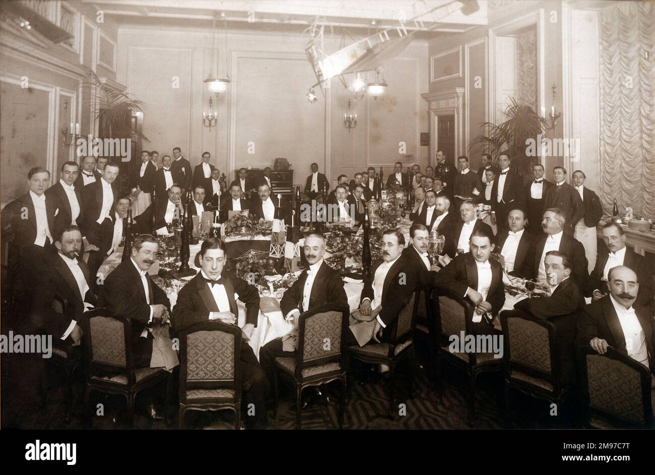 The ‘Upside Down Dinner’ given by the Hendon Aviators to Bentfield Hucks and Gustav Hamel at the Royal Automobile Club on 16 January 1914. Standing guests from left: Gustav Hamel, Claude Grahame-White (Chairman) and B.C. Hucks. Stock Photo