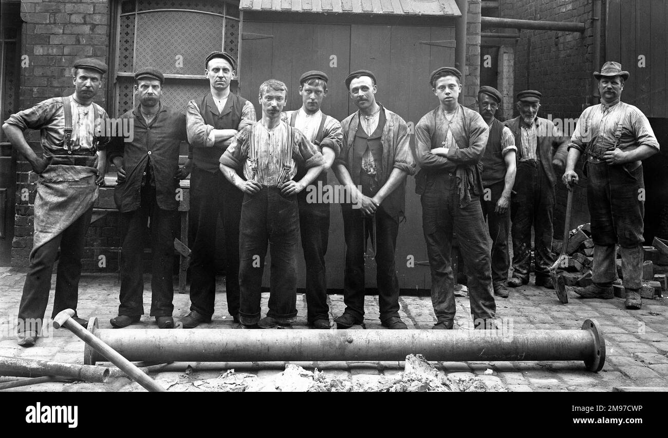 Group outside engine house at hat factory in Stockport in June 1906, showing Edwardian factory work clothes. 9 out of 10 wearing hats, and two in wooden clogs. Stock Photo