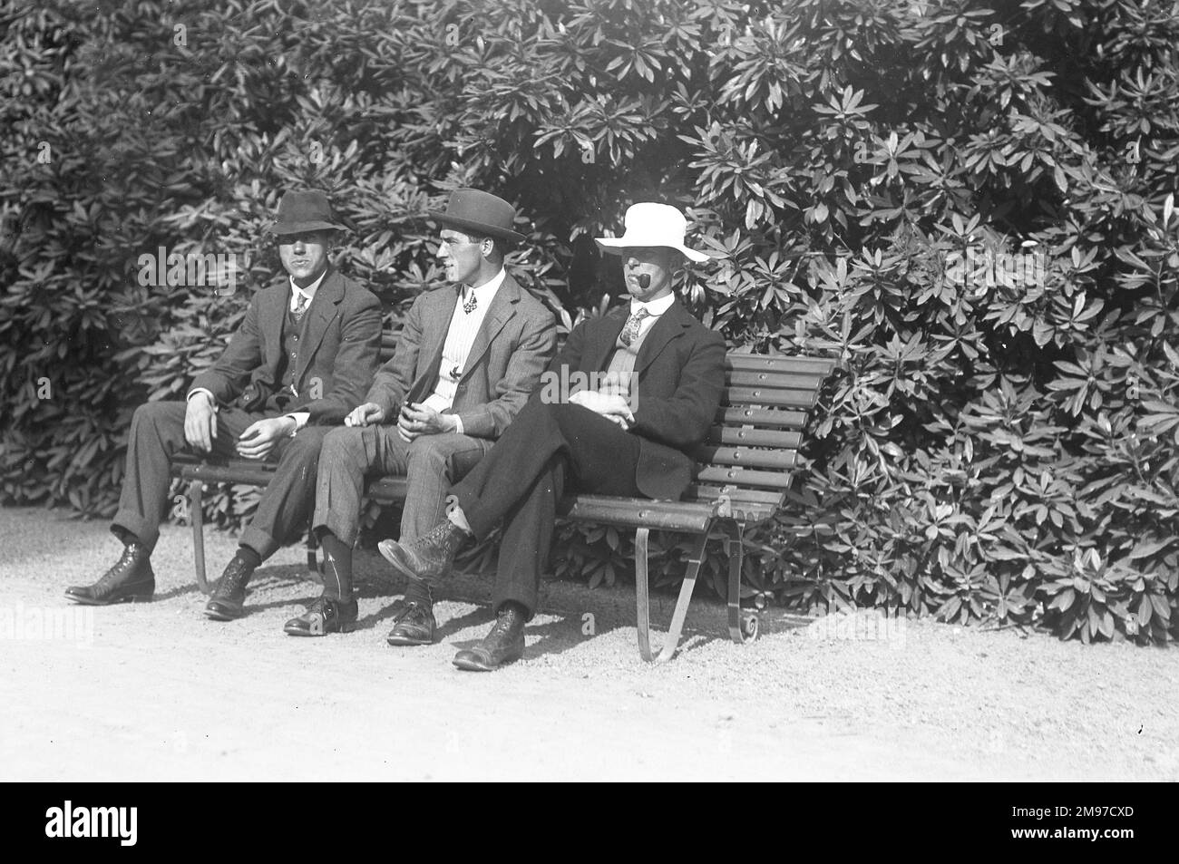 Three men on a bench in Edwardian England - one gets the impression that they are not taking the occasion entirely seriously. Stock Photo