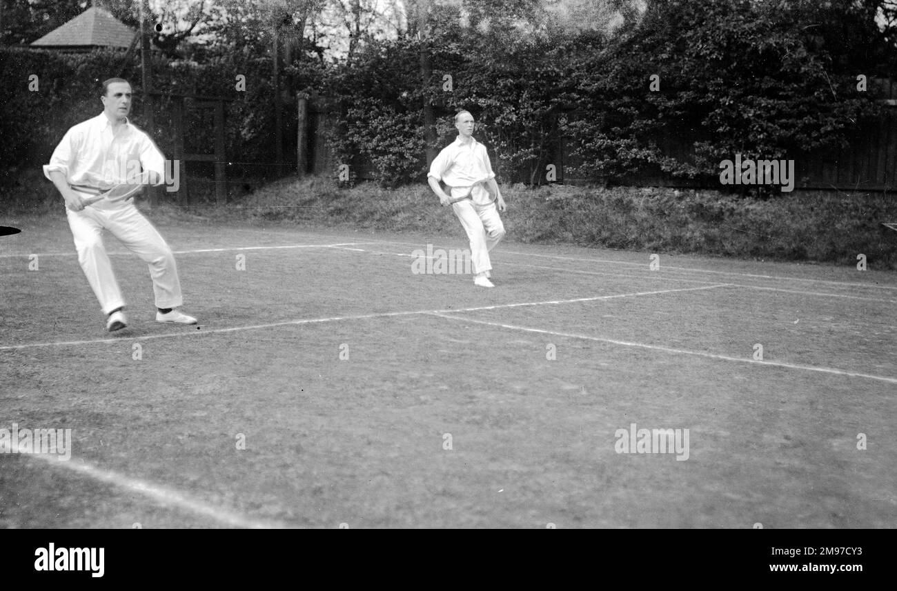 Men's doubles tennis match at Moorfield Tennis Club, Stockport - a good action shot, considering the limitations on contemporary equipment Stock Photo