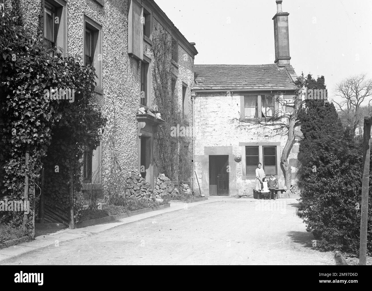 Labelled as the Eyam Ball Hotel, this shows the street approaching the dwelling mentioned  - it also notes the piles of rock by the front door which may have been in place for use as a flood defence. Stock Photo