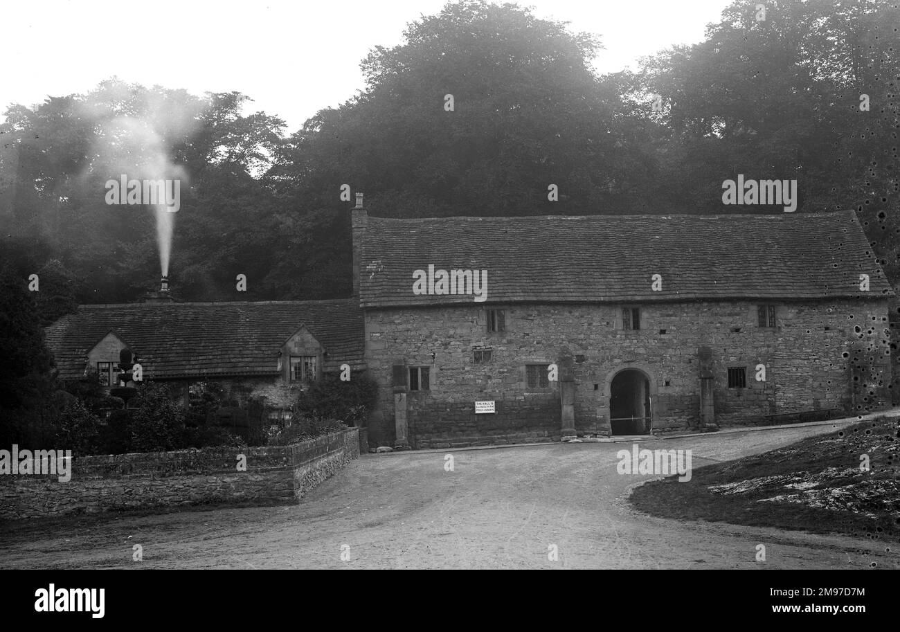 Little changed to this day, this buildinghas stood at the bottom of the slope leading to Haddon Hall for centuries. The chimney smoke gives an idea of the exposure time and also the weather conditions. The sign on the building informs that the Hall is closed to the public on Sundays! Stock Photo