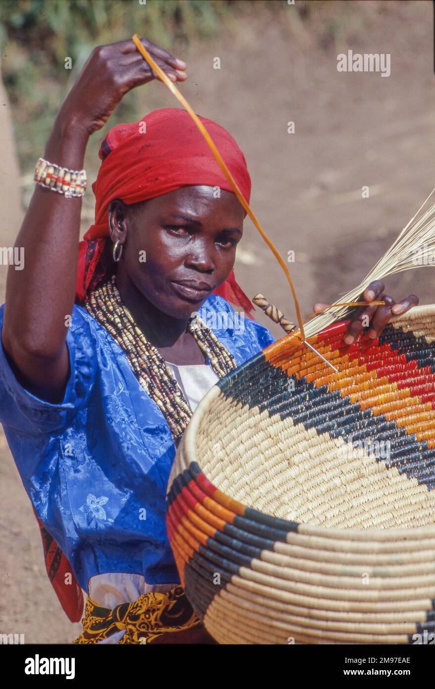 Uganda, Kampala; Portrait of a woman weaving traditional baskets Stock