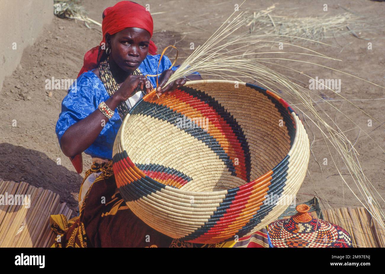 Uganda, Kampala; Portrait of a woman weaving traditional baskets Stock