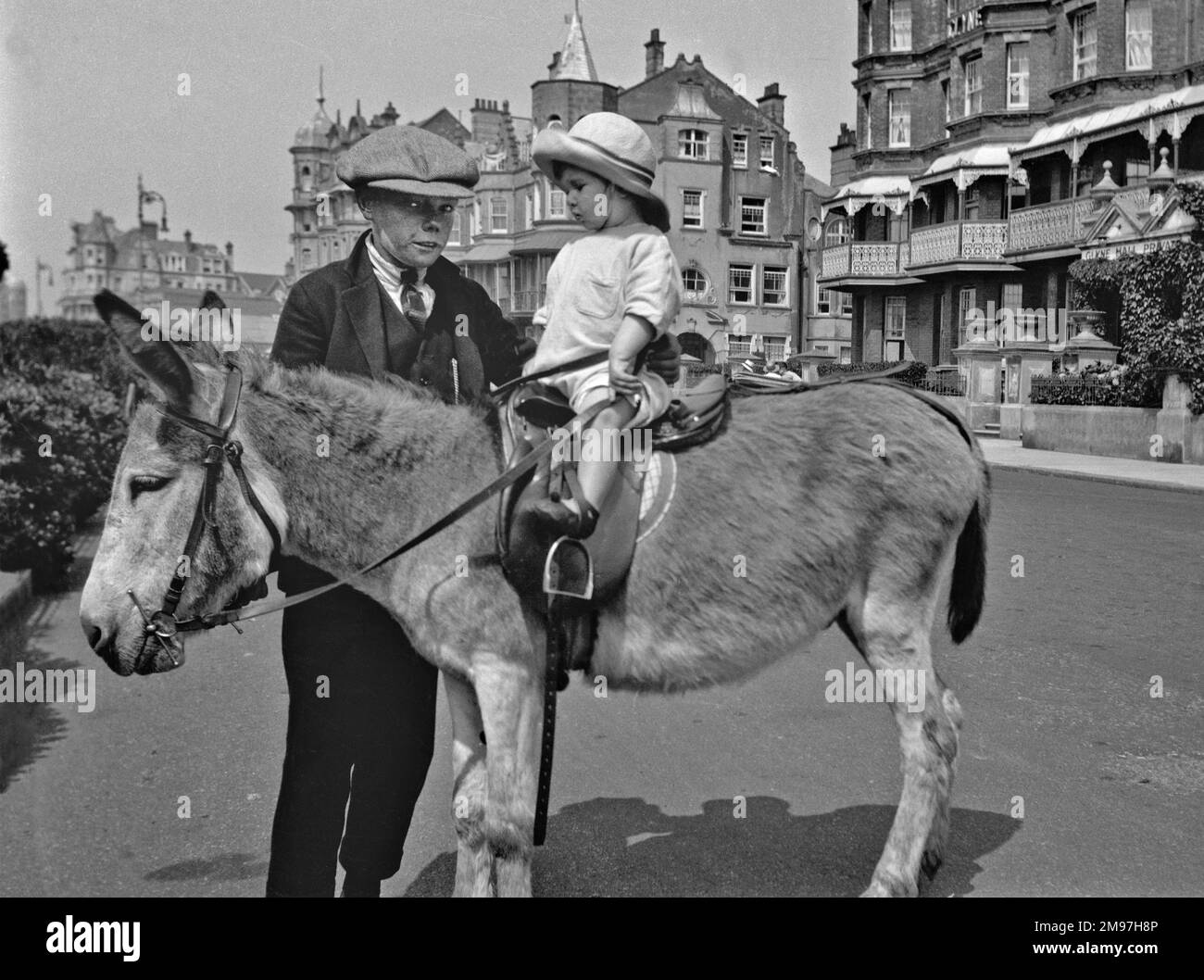 Two children with a donkey at the seaside. Stock Photo