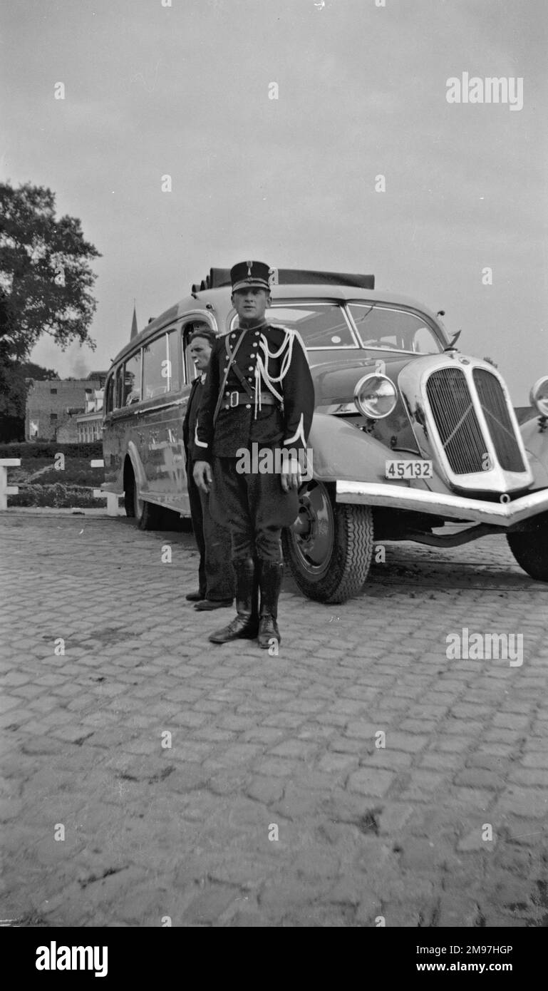 Man in military uniform (possibly Italian or French) standing by a coach. Stock Photo