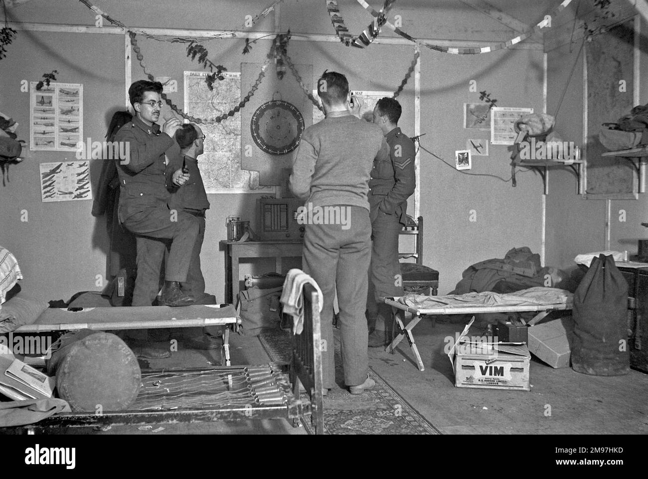Four soldiers playing darts in an army hut. Stock Photo