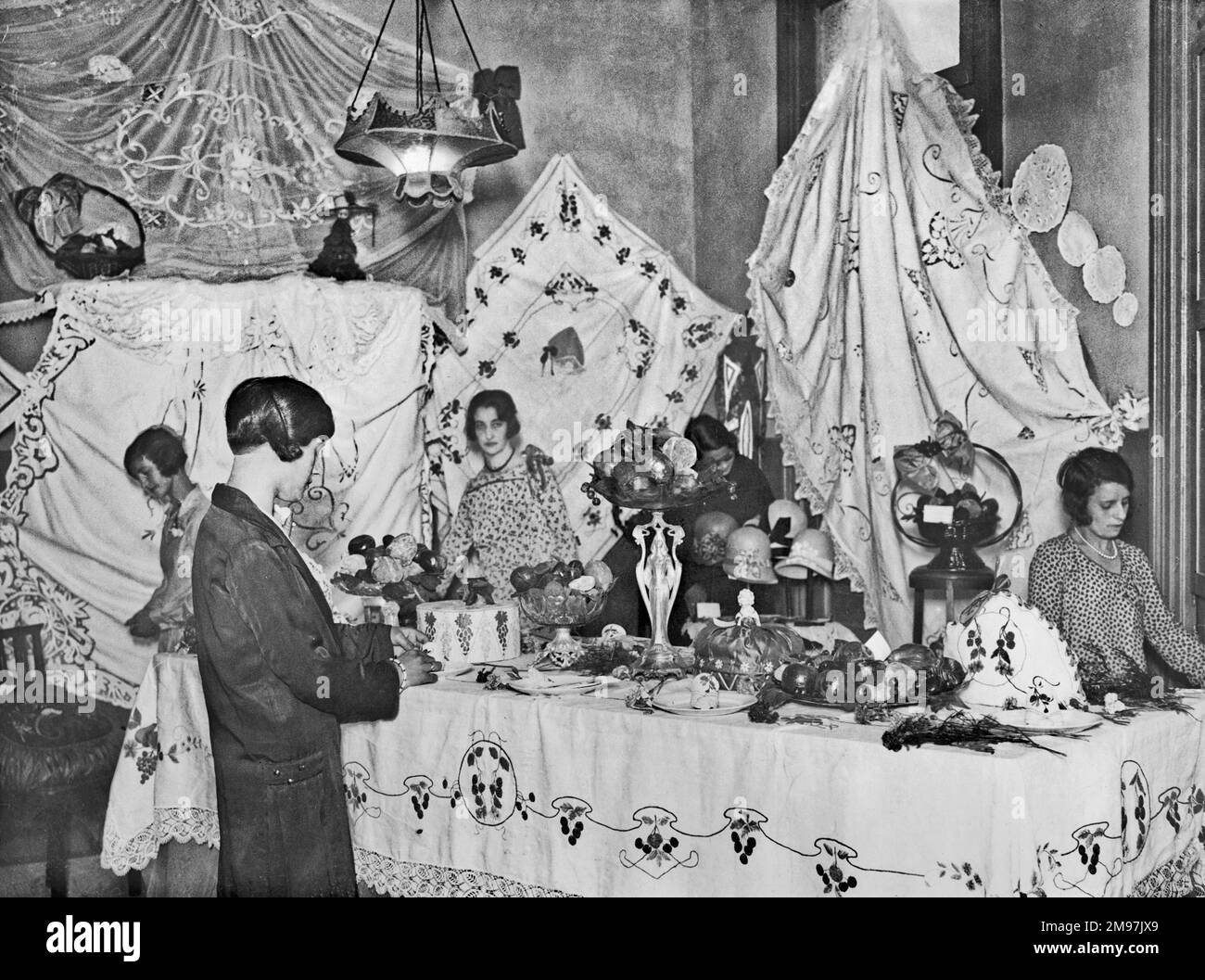 A group of women with a display of homemade arts and crafts. Stock Photo