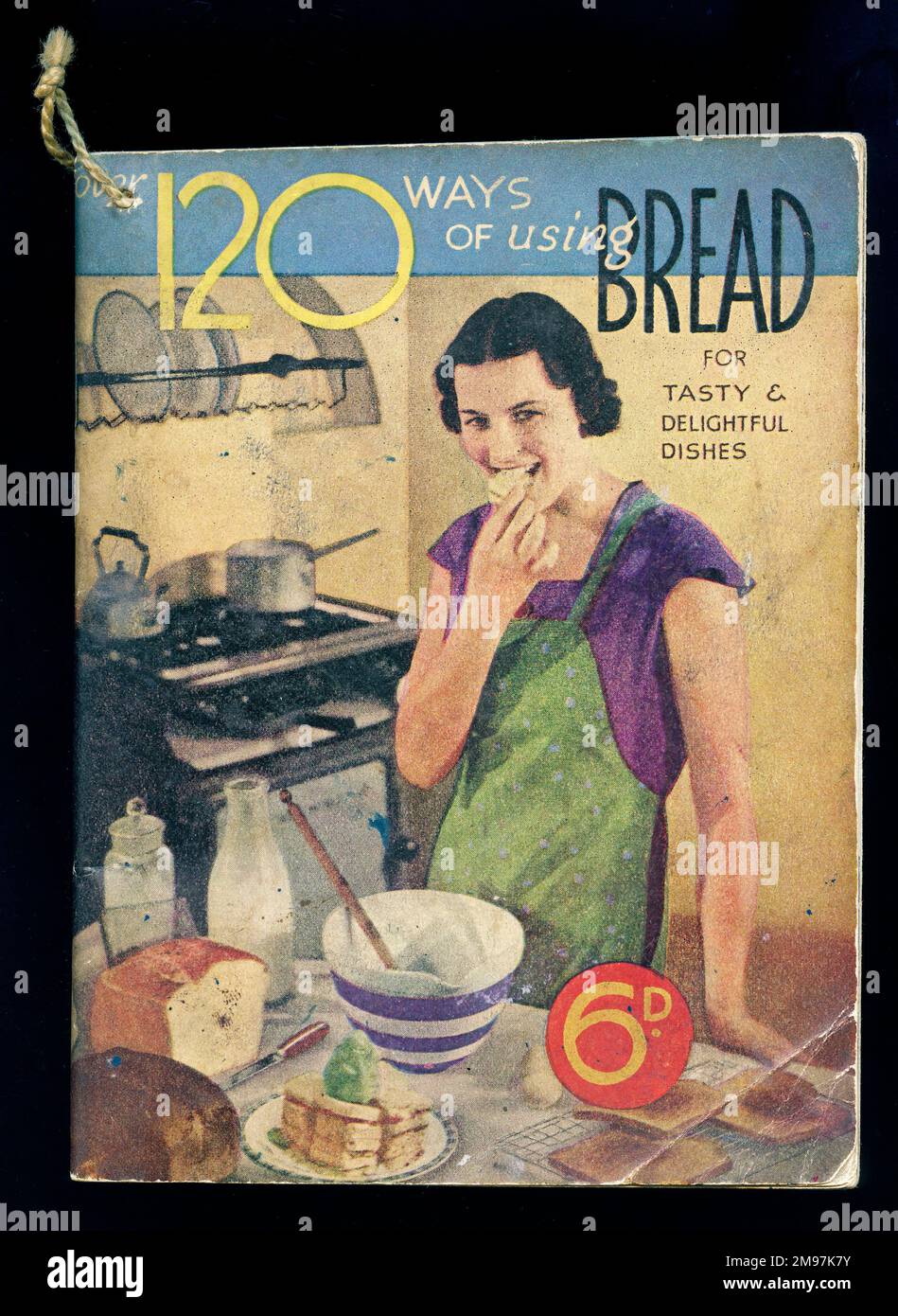 Cover design, Over 120 Ways of Using Bread for tasty and delightful dishes. Showing a woman in her kitchen, enjoying some of the results of her baking. Stock Photo