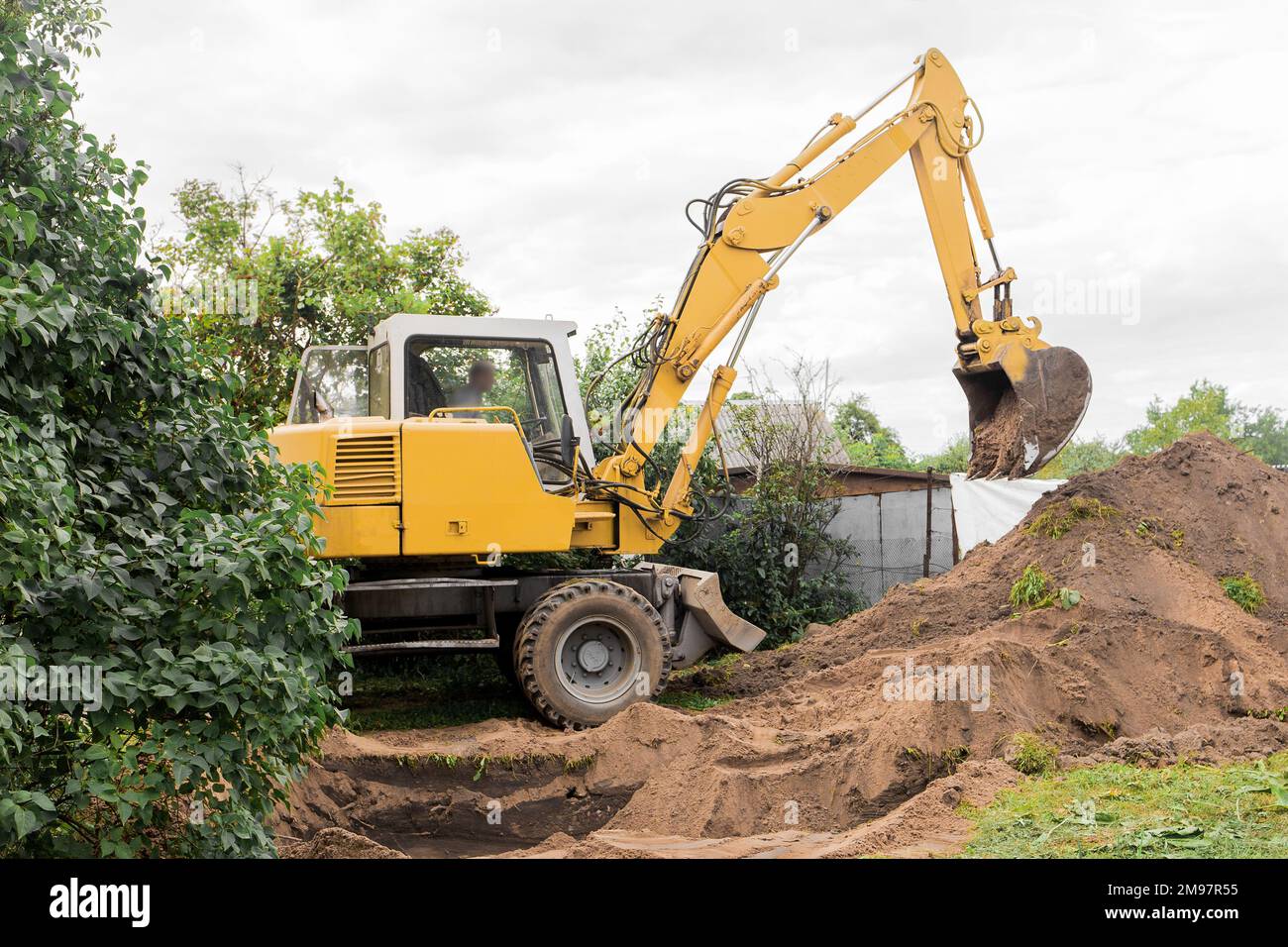 A excavator is digging on outdoors in an industrial site. Excavation works. Stock Photo